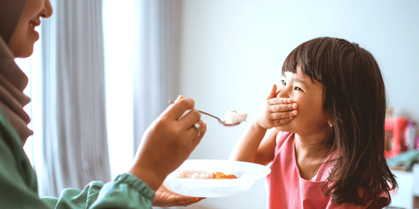 Mother feeding child in a fun environment