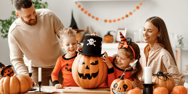 A family spending an afternoon painting pumpkins as one of their fall family activities.